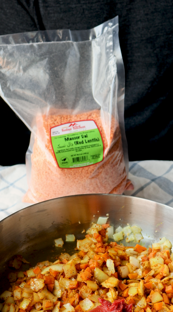 To make this creamy red lentil soup, begin by sautéing onions and minced garlic in oil. Then add carrots and seasonings. Cook for a few minutes, then add tomato paste, red lentils, and water. Bring to a boil, then cover and cook on super low for 30 minutes, or until lentils and carrots are soft. Blend until smooth, then add heavy cream. Add more heavy cream if a more soupy consistency is desired. Top with red pepper flakes and cilantro and enjoy!